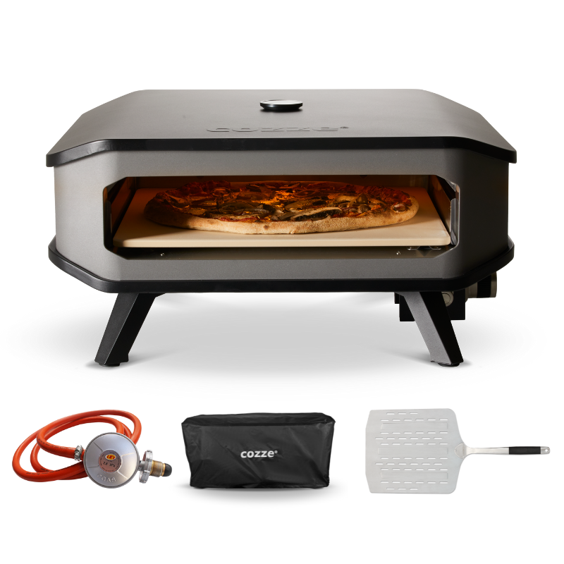 A black COZZE brand gas pizza oven with a pizza inside, a red gas hose, a black paddle, and a black carrying case.