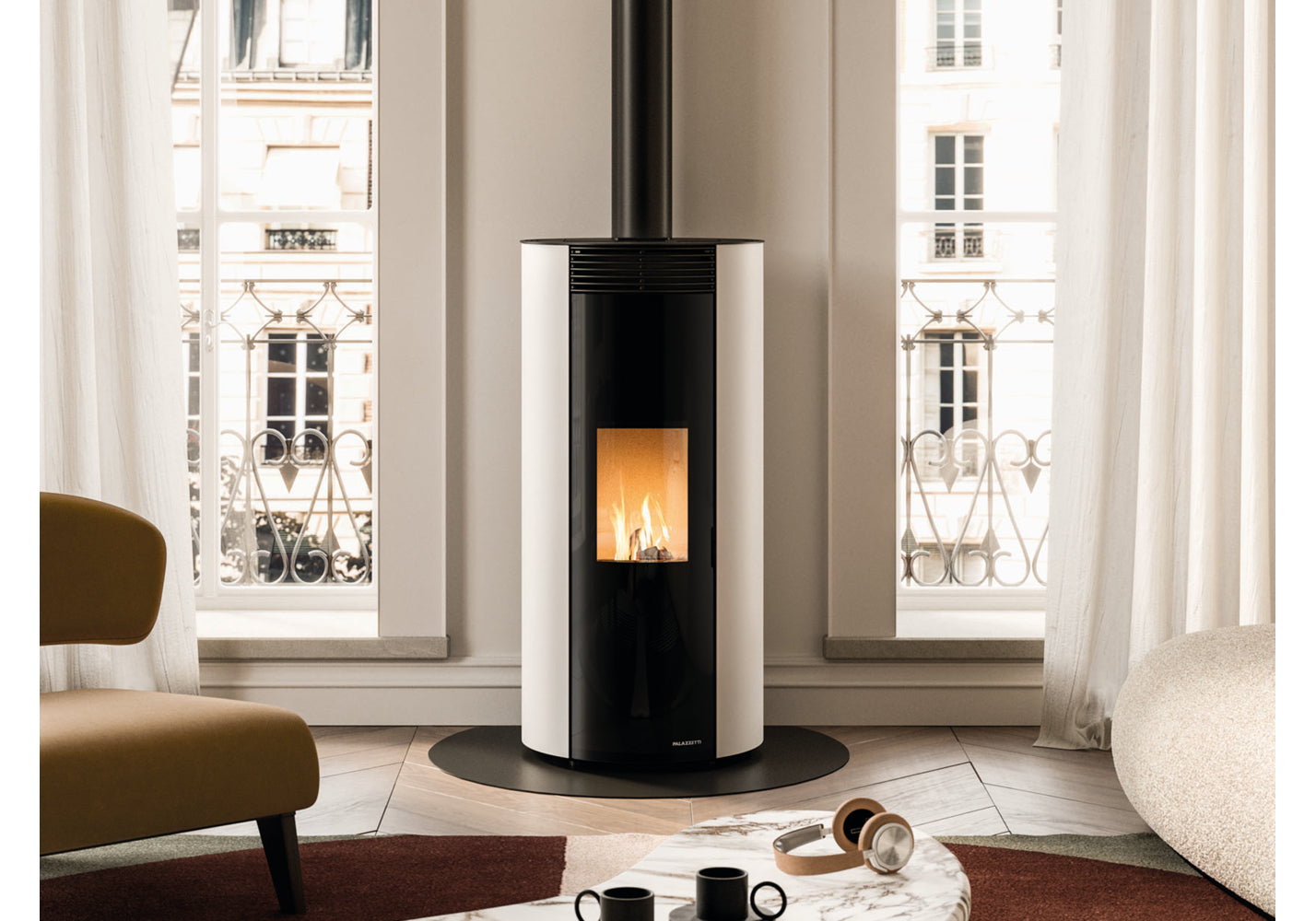 Modern freestanding stove in a living room with large windows.