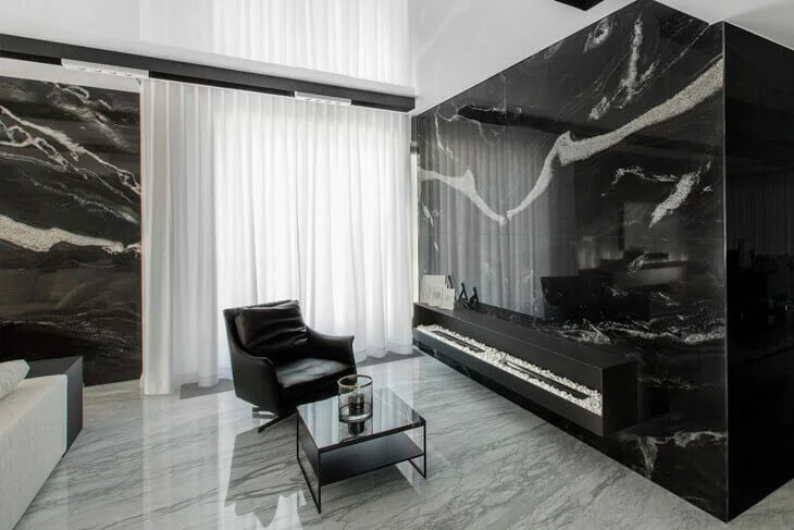 Modern living room with black marble walls and furniture.
