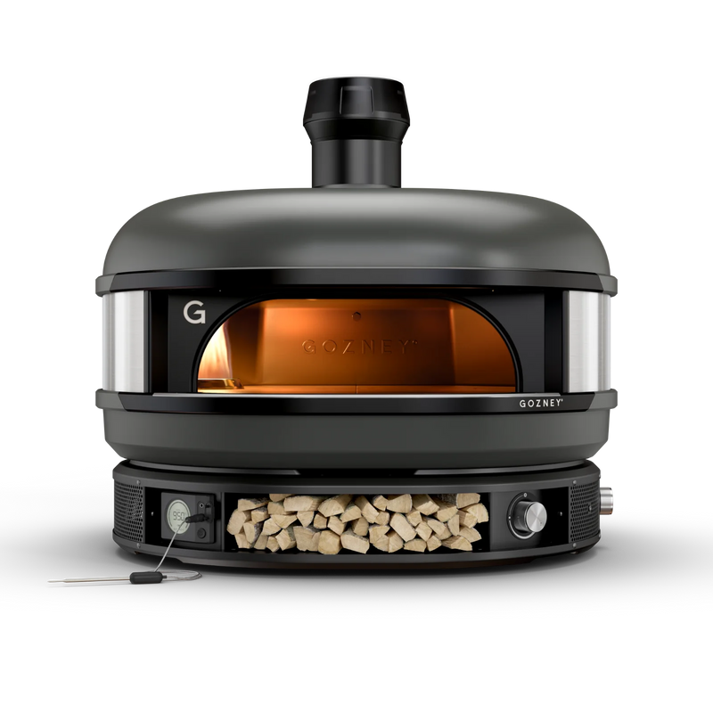 Black Gozney pizza oven with wood storage on a white background