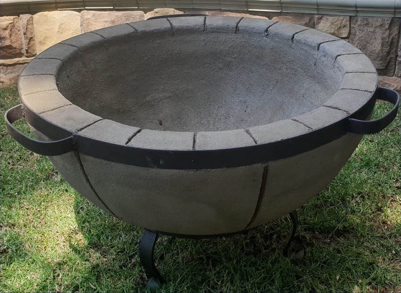 Stone fire pit on grass with stone wall background
