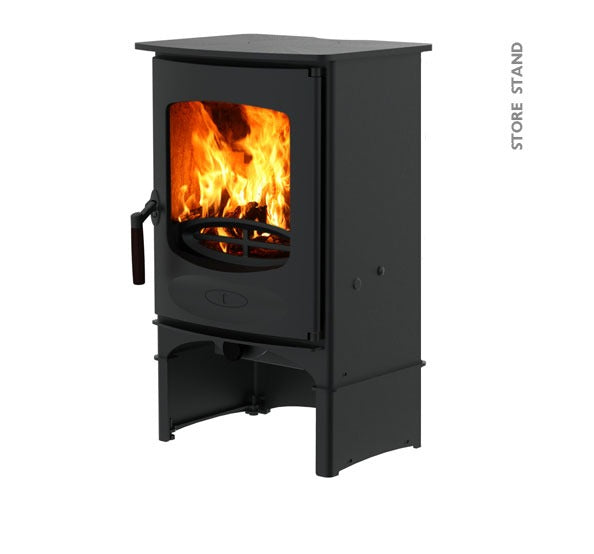 A black Charnwood C-Four wood stove with a stand, featuring a visible fire through the glass door.