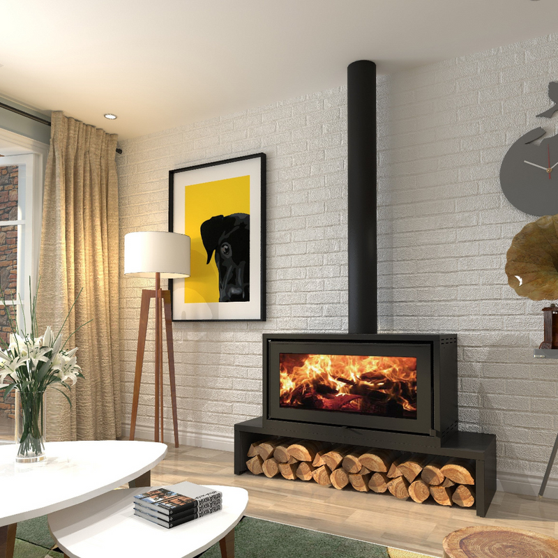 A freestanding black wood stove with a visible fire inside, situated in a room with a white brick wall, a window, a picture frame, and a floor lamp.