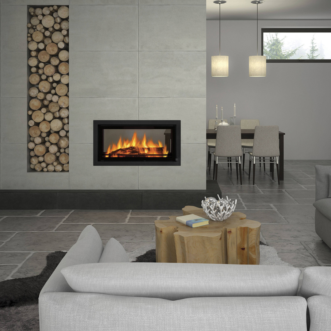 Modern indoor living space with a fireplace insert, featuring a white sofa, a wood storage wall, and a dining area in the background.