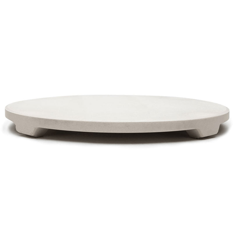 A beige, round ceramic pizza stone with a slight lip on the edge.