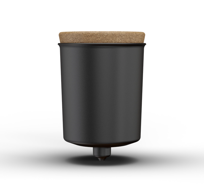 Black cylindrical container with a cork lid on a white background