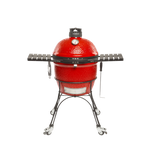 A red ceramic Kamado Joe Classic II charcoal grill with a steel wire cart and locking wheels, featuring side shelves and a built-in thermometer.