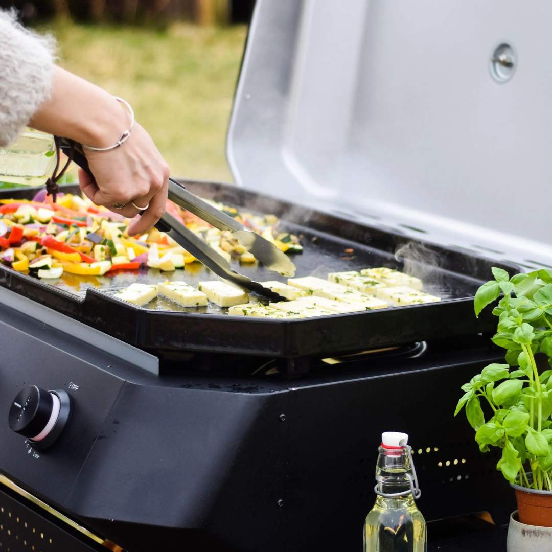 Plancha 500 flat-top grill in use outdoors, versatile searing and griddling.