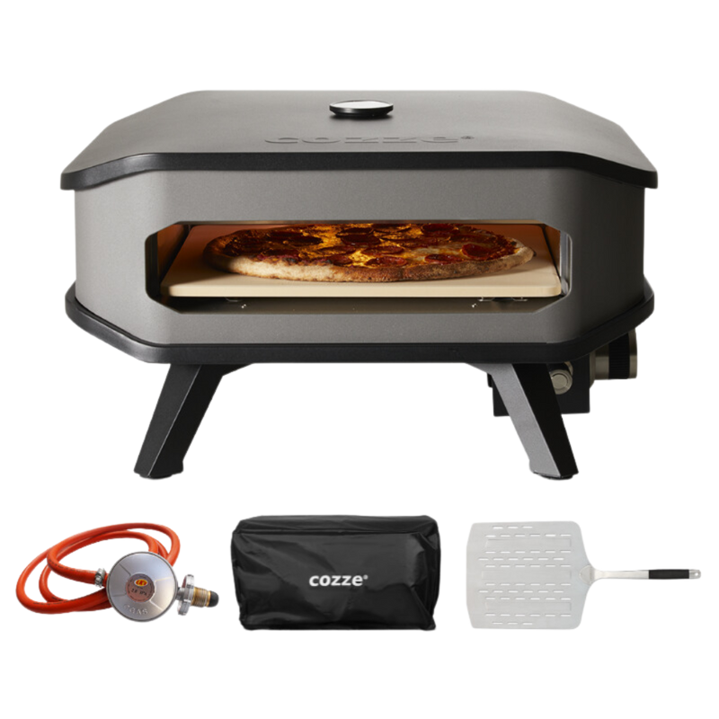 A COZZE brand gas pizza oven with a pizza inside, alongside accessories including a gas regulator and a paddle. The oven is black and gray in color.