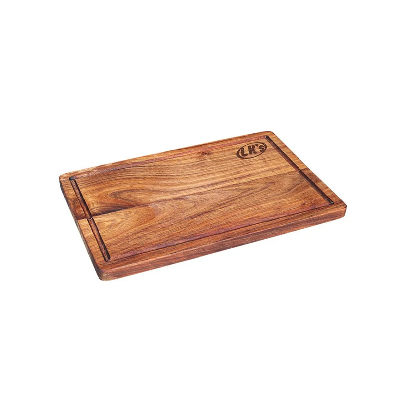 A rectangular wooden cutting board with a natural brown grain and a branded logo on the lower right corner.