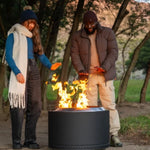 Two people by a fire pit in a park setting