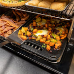 Grilled vegetables with a sunny-side-up egg on a grill pan, surrounded by other food items.